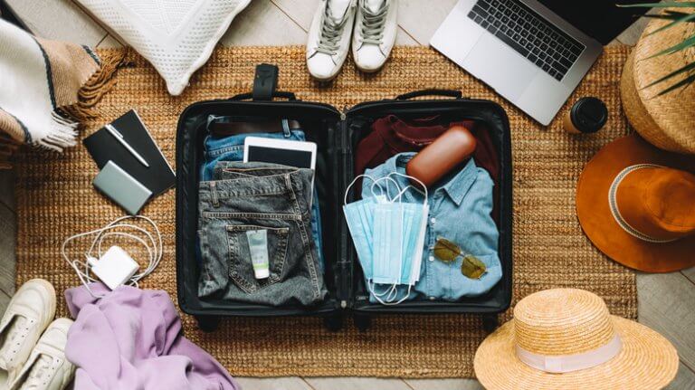 Packing suitcase for travel vacation in new normal, top view